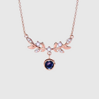 Rose gold necklace with leaf design and blue gemstone, featuring a photo pendant of a couple and baby.